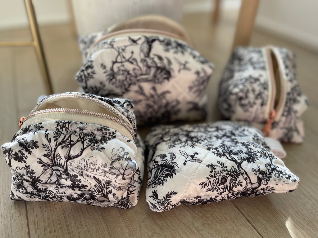 Set of floral-patterned pouches on a wooden surface